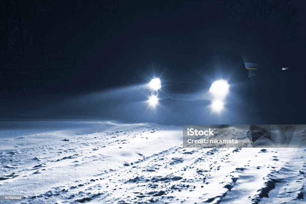 Conducción de coche en una carretera de campo nívea de una tormenta de nieve. - Foto de stock de Faro - Luz de vehículo libre de derechos