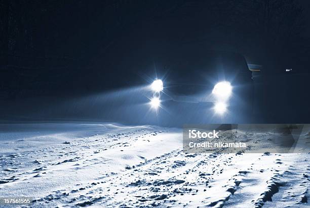 Conducción De Coche En Una Carretera De Campo Nívea De Una Tormenta De Nieve Foto de stock y más banco de imágenes de Faro - Luz de vehículo