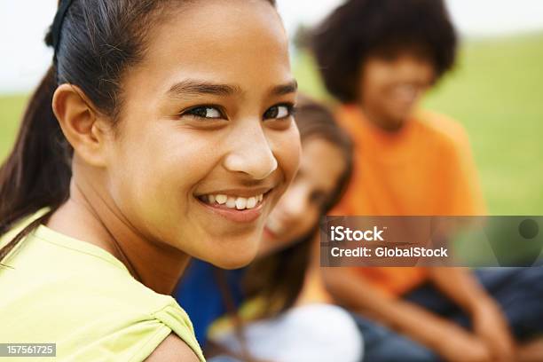 Ragazza Sorridente Con Gli Amici In Background - Fotografie stock e altre immagini di 10-11 anni - 10-11 anni, Abbigliamento casual, Allegro