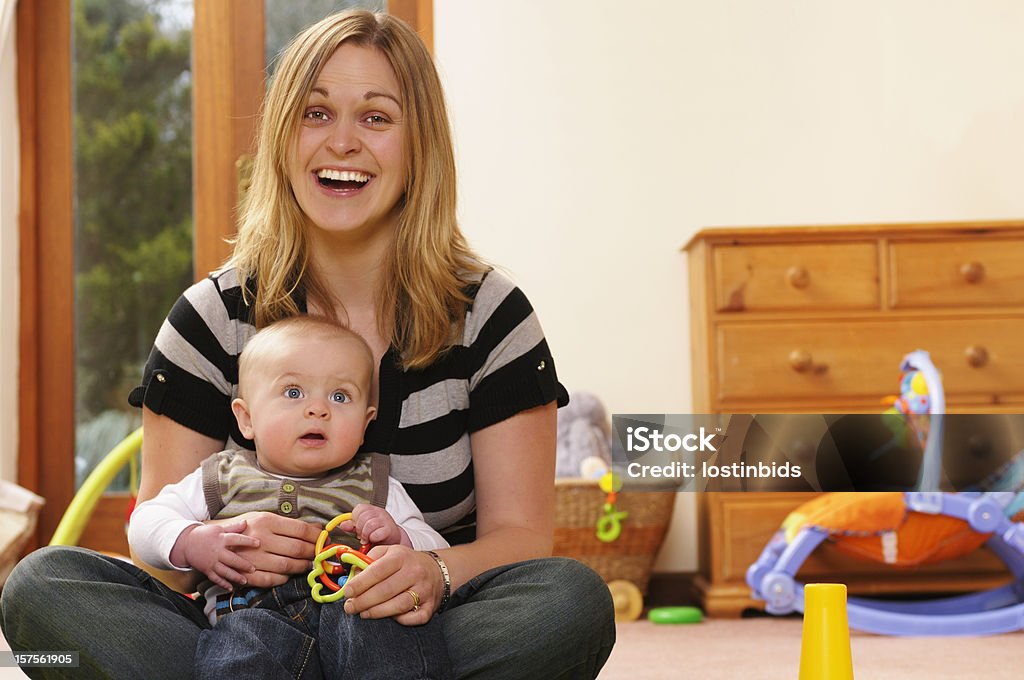 Caucasion donna con un bambino e sorridente - Foto stock royalty-free di Bebé