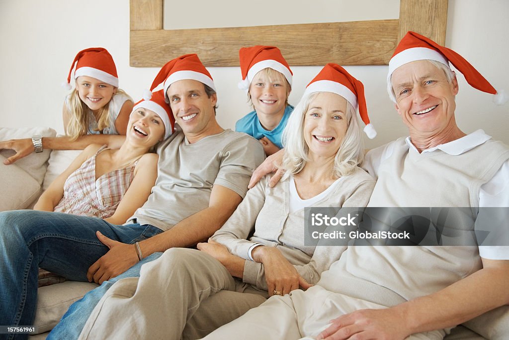 Familia Multi generacional estar juntos usando sombrero de Santa's - Foto de stock de 30-39 años libre de derechos