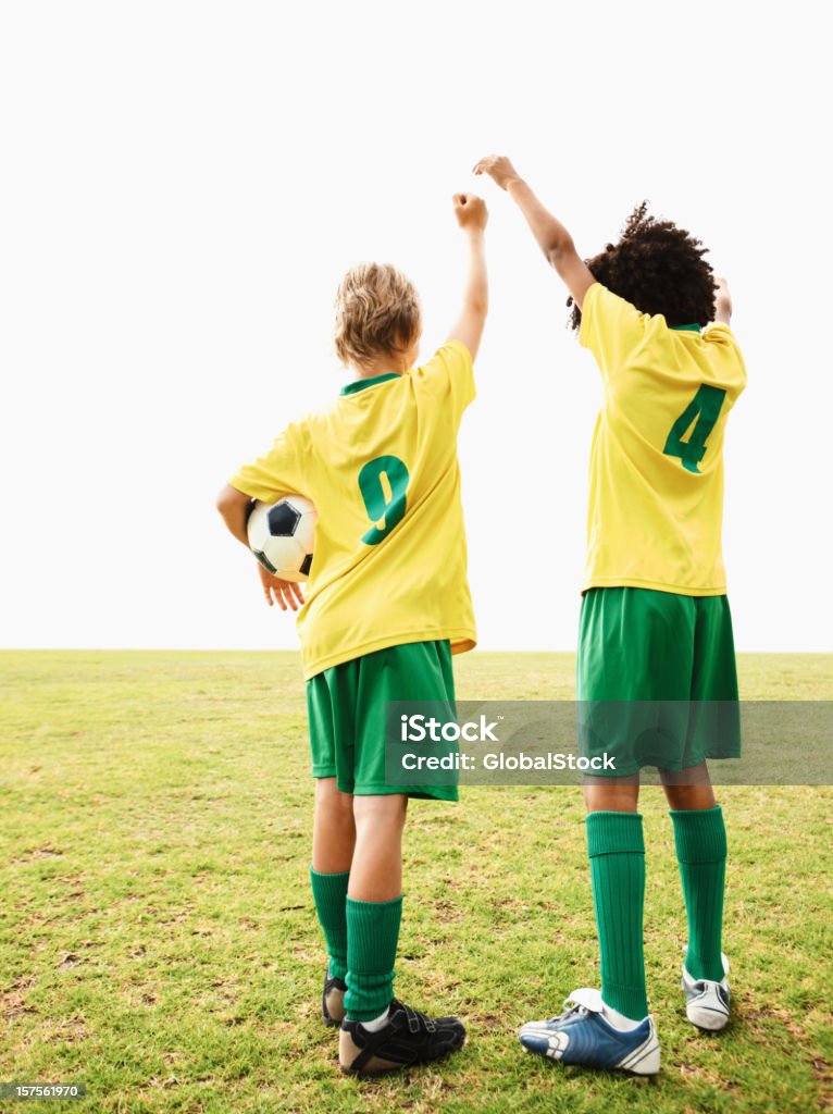 Vista posterior de los jugadores de fútbol en el campo - Foto de stock de Alzar la mano libre de derechos