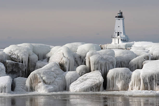 Great Lakes Lighthouse with ice covered rocks in foreground Ludington Michigan's Light with ice covered rocks in the foreground   lake michigan photos stock pictures, royalty-free photos & images