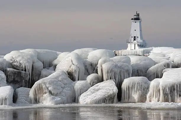 Photo of Great Lakes Lighthouse with ice covered rocks in foreground