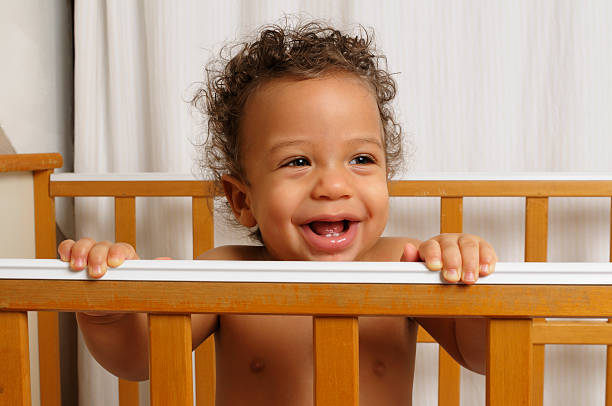 istock Seven month old baby standing in his cot 157562047