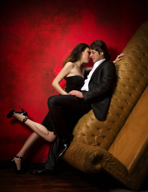 istock Sexy couple embracing against leather couch 157562112