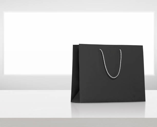 istock black paper bag on white wooden table 1575623197