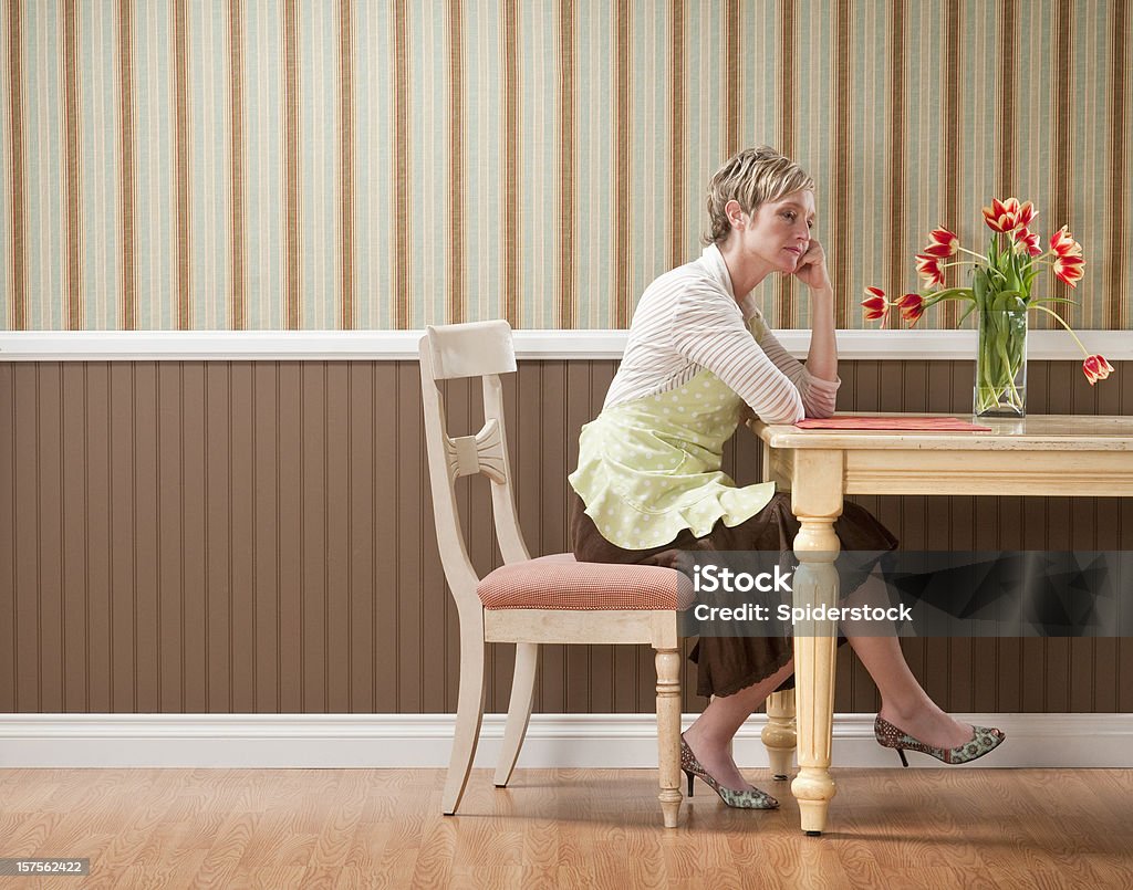 Femme triste à la Table de salle à manger - Photo de Végétation fanée libre de droits