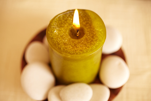 Spa still life of green candle with white pebbles