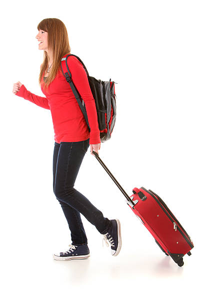 young woman walking with suitcase stock photo
