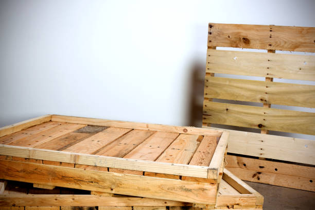 Close-up of stacked wooden pallets piled in an industrial storage area showing worn and damaged boards.