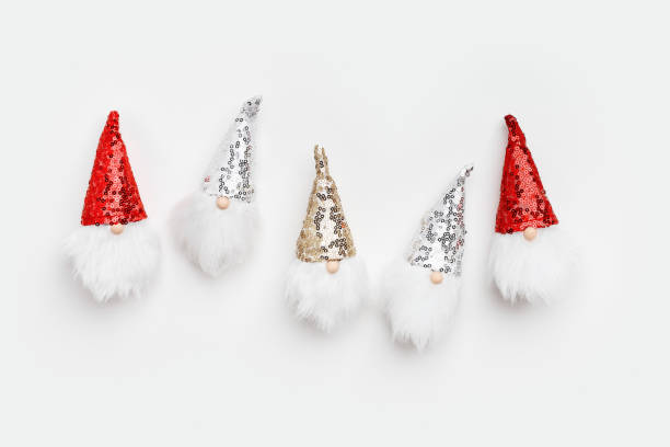 istock Christmas composition. Cute dwarfs with white beard and glittering sequins on cap white background. Christmas, winter, New Year concept. Flat lay, top view wallpaper, minimal holiday pattern 1575628018