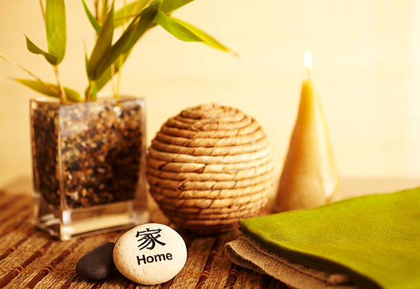 Home decor still life of home river rock with bamboo in vase with wicker ball, candle and river stones close-up