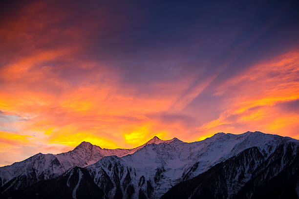 istock The sky and clouds glowing orange over snowy mountains 157563083