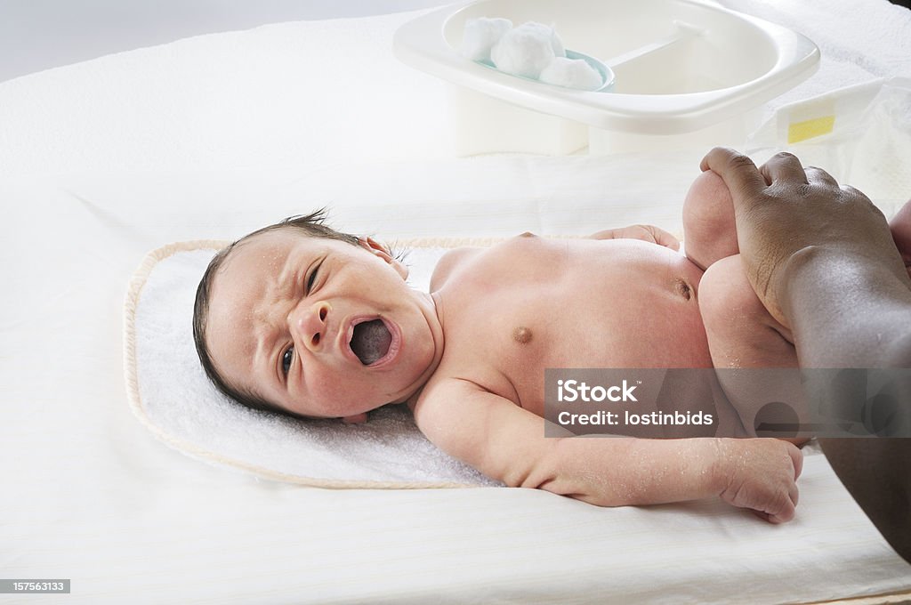 Changing a Newborn Baby's Nappy A high key image of newborn baby (18 days) being cleaned during a nappy change Newborn Stock Photo
