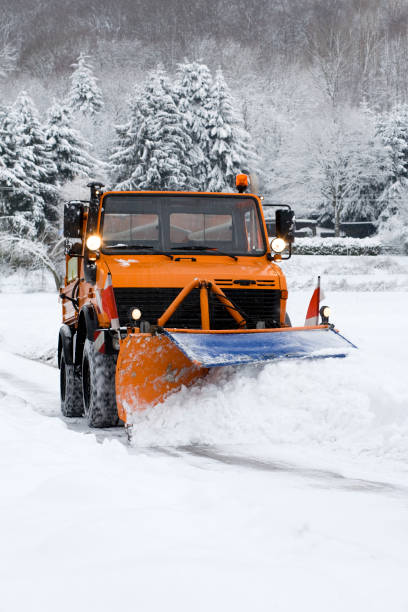 istock Orange truck with snow plow, winter forest 157563250