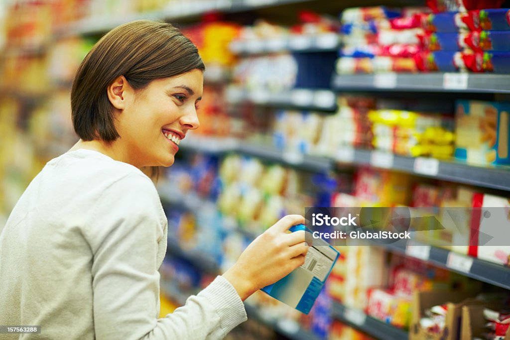 Heureuse Femme dans un supermarché choisir des produits - Photo de Choisir libre de droits