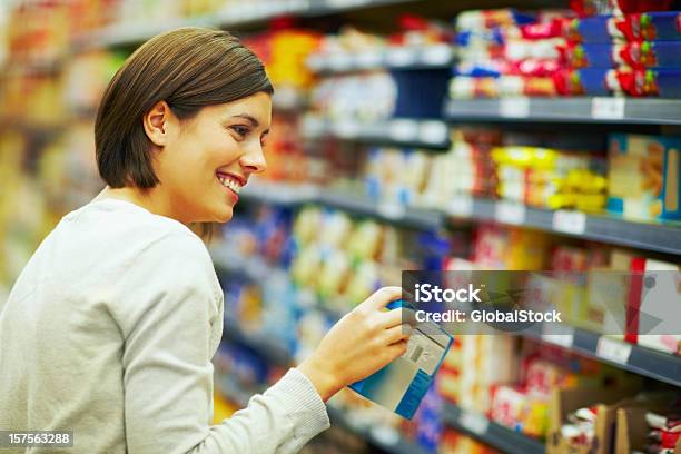 Photo libre de droit de Heureuse Femme Dans Un Supermarché Choisir Des Produits banque d'images et plus d'images libres de droit de Choisir