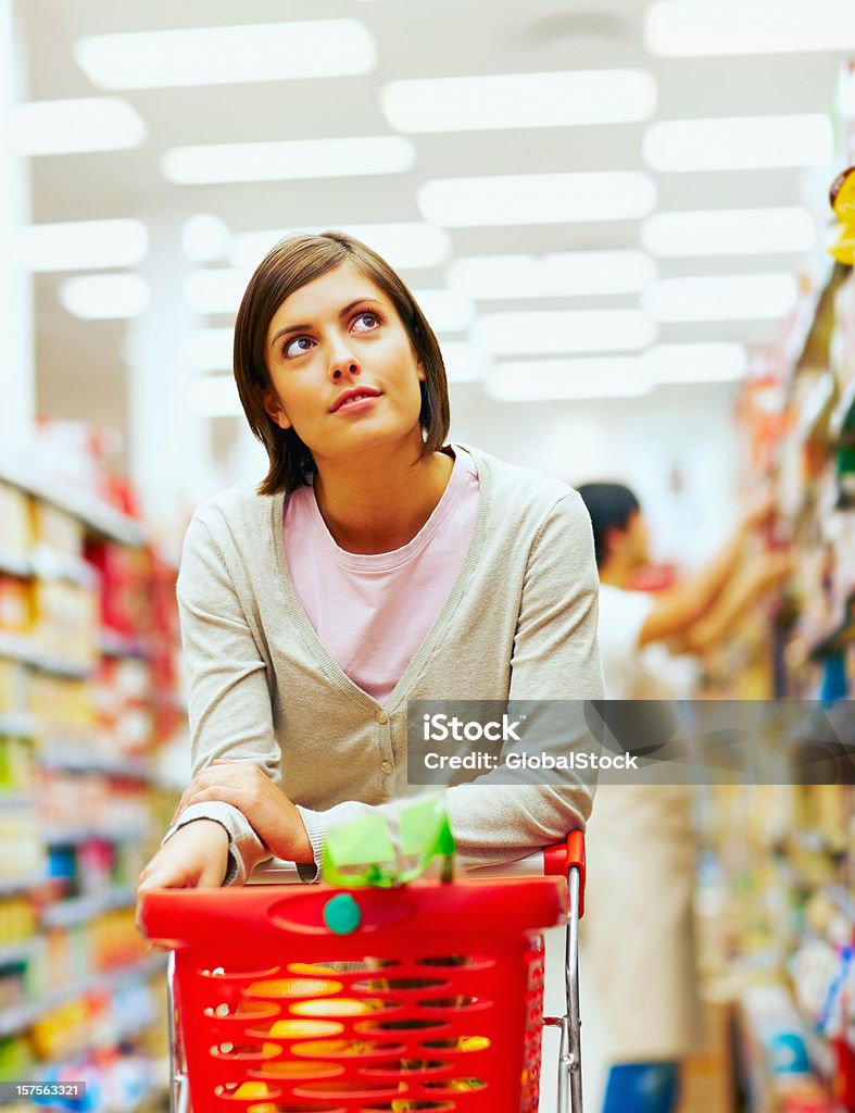 Jovem mulher com um vermelho carrinho de compras no supermercado - Royalty-free Supermercado Foto de stock