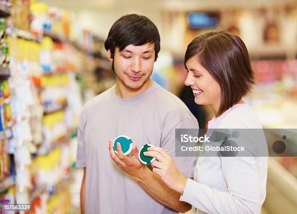 Foto de Casal Decidir Em Um Produto Para Compra No Supermercado e mais fotos de stock de 20-24 Anos