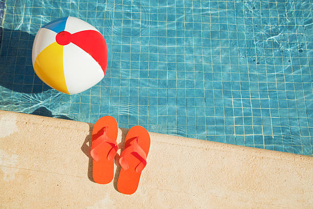 piscina vacaciones de verano divertido con una pelota de playa, sandalias flotante - floatation device fotografías e imágenes de stock