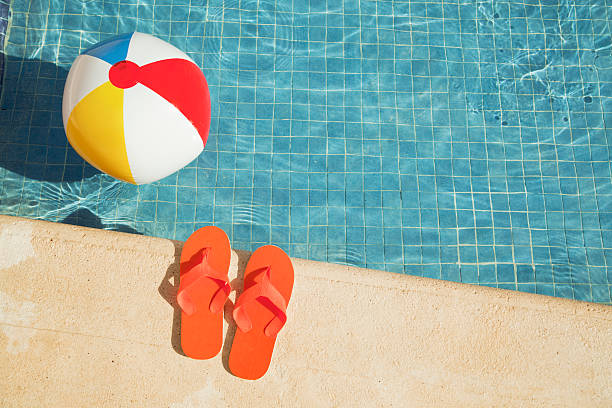 piscina de férias de verão flutuando diversão com bola de praia, sandals - bola de praia - fotografias e filmes do acervo