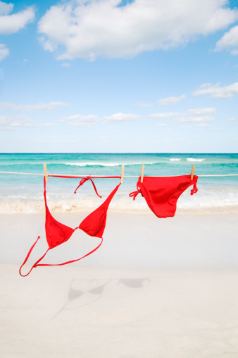 Subject: Bikini hanging on a clothesline over a idyllic tropical beach.