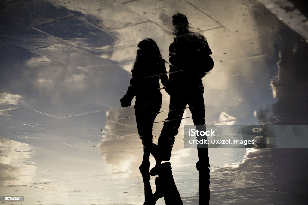 Lovers of Rain Silhouettes of Rain / reflections on puddle , Canon 5DII Couple - Relationship Stock Photo