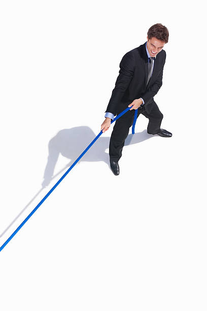 istock Young business man pulling a rope isolated on white 157563910