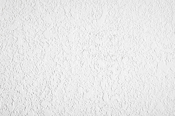 high contrast textured white plaster wall textured white plaster wall lit with high contrast light for more exaggerated texture and background stucco stock pictures, royalty-free photos & images