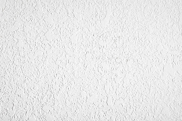 high contrast textured white plaster wall textured white plaster wall lit with high contrast light for more exaggerated texture and background painted drywall texture stock pictures, royalty-free photos & images