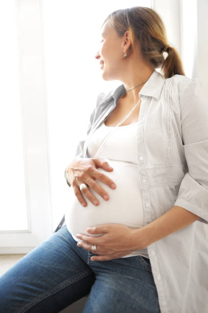 istock pregnant woman in a window 157564085