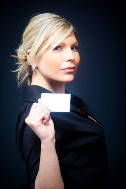 Blond businesswoman with empty business card stock photo