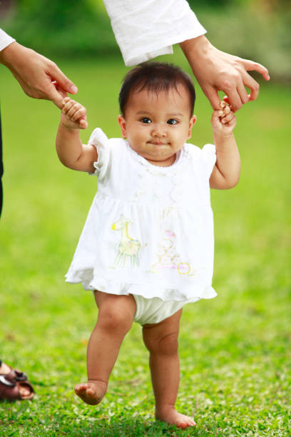 istock lovely baby learn to walk 157564204