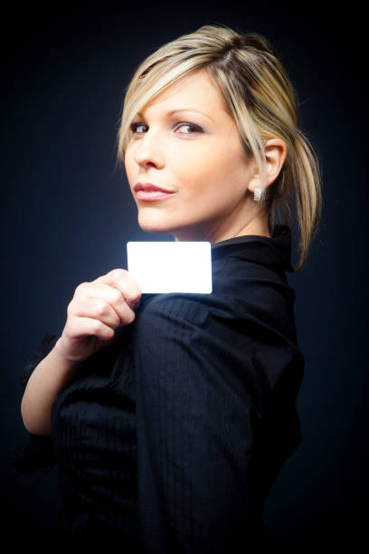 Blond businesswoman with empty business card stock photo