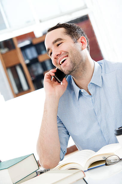istock Man Sitting at a Desk Talking on Cell Phone 157564548