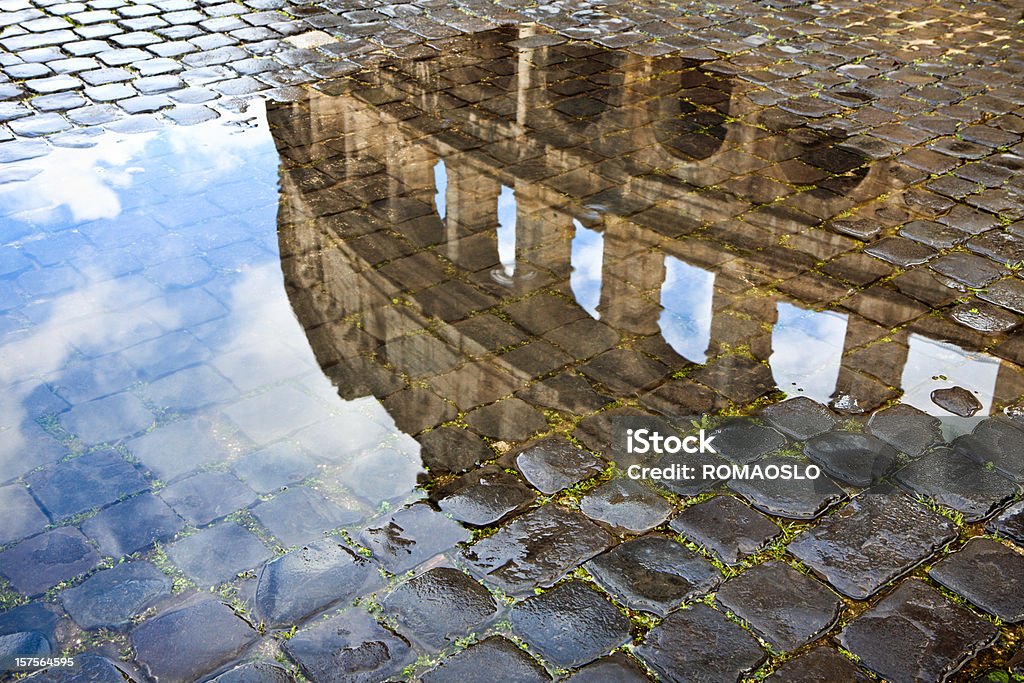 Colosseo riflessa in una pozzanghera e ciottoli. Roma, Italia - Foto stock royalty-free di Pozzanghera