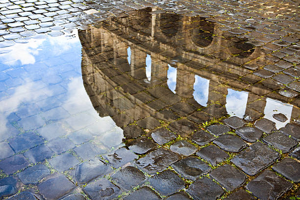 istock Coliseum reflected in a puddle and cobblestones. Roma Italy 157564595