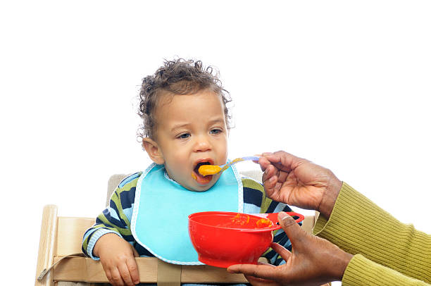 Weaning Baby Having Homemade Food A baby eating a  homemade meal as part of his weaning regime boys bowl haircut stock pictures, royalty-free photos & images
