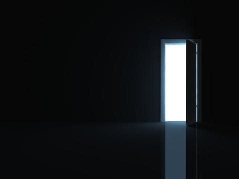 Black room with opened door into the light
