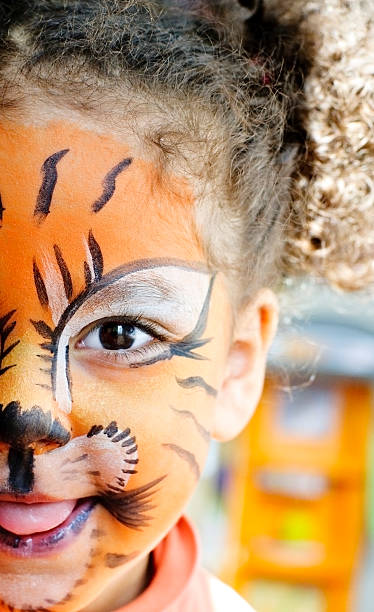 heureux enfant avec sa tête de tigre peinture. - bouclette de cheveux photos et images de collection