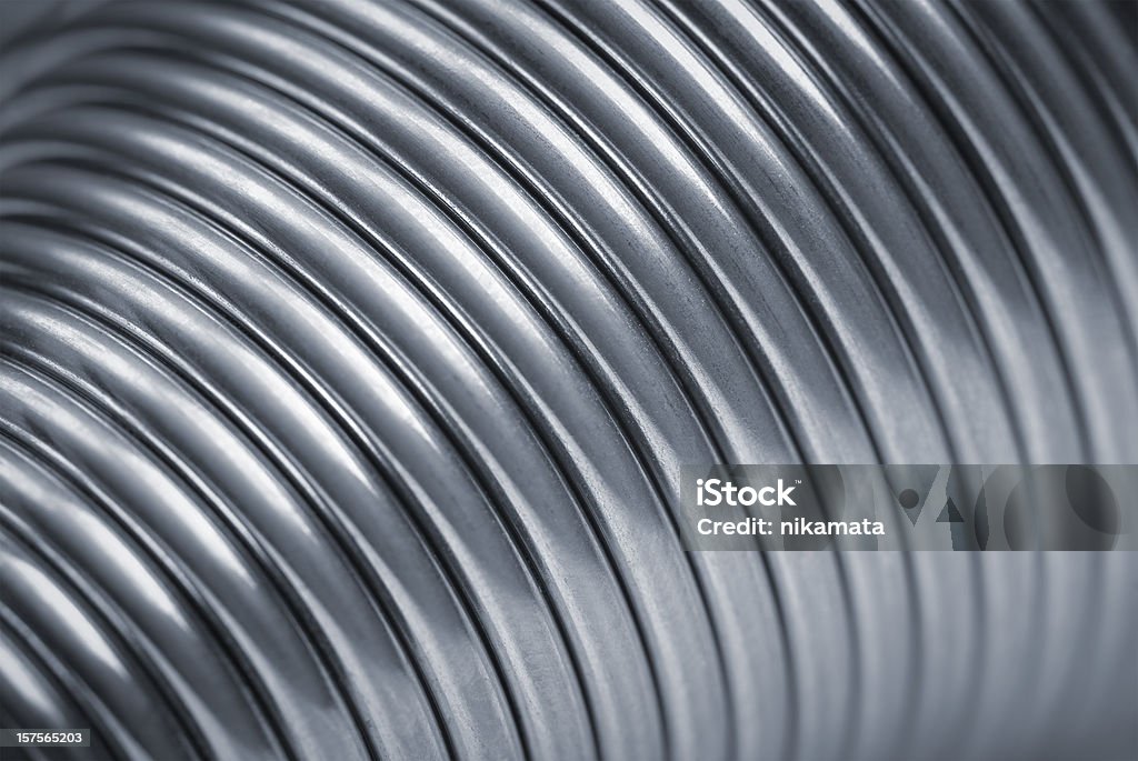 Close up of silver metal rings Metallic spiral (coil). Spiral rings are a reflection of the metallic color. In the photo - a part of the torus in the form of a coil spring. Сlose up shot. Color Image Stock Photo