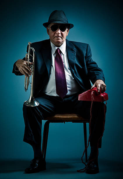 old jazz musician waiting for a phone call elegant trumpet player waiting for a possible contract call man trumpet stock pictures, royalty-free photos & images