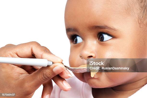 A Baby Being Fed Baby Food On A White Spoon Stock Photo - Download Image Now - Baby - Human Age, Feeding, Eating