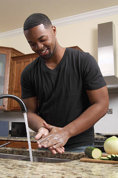Man washing his hands on the kitchen sink