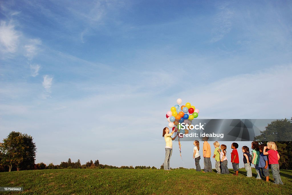 Niños esperando en línea para los globos al aire libre - Foto de stock de 14-15 años libre de derechos