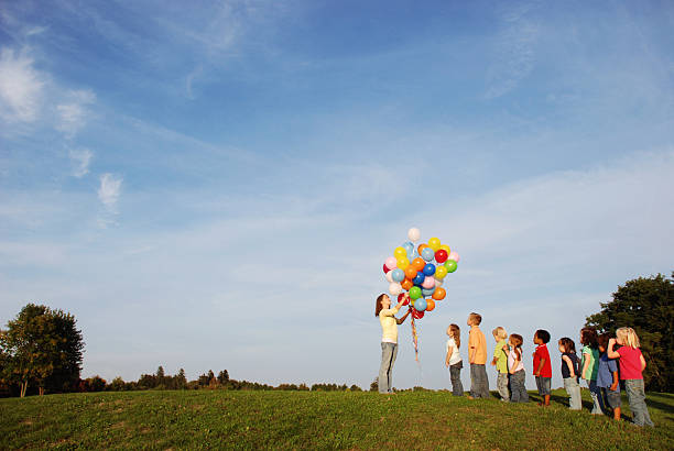 istock Children Waiting in Line for Balloons Outside 157565662
