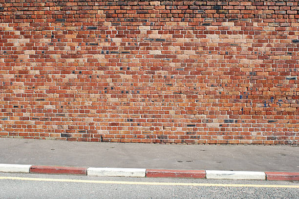 istock Urban background UK - Red brick wall with sidewalk 157565991
