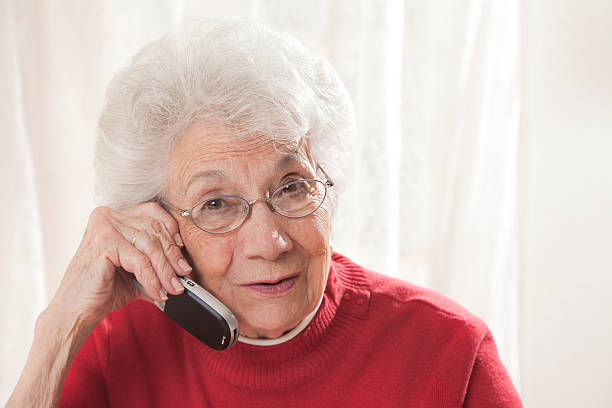 senior mujer hablando por teléfono - cordless phone telephone landline phone telephone receiver fotografías e imágenes de stock