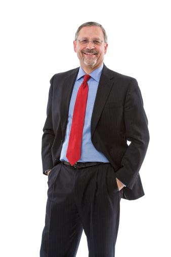 mature businessman wearing suit, blue dress shirt, and red necktie.